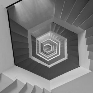 Un escalier hexagonal est vu d'en bas et se prolonge à l'infini donnant le vertige, illustre la répétition de schémas