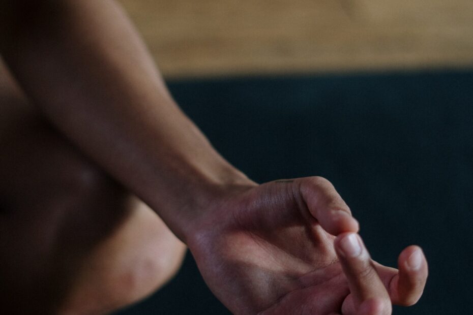 Focus sur une main faisant le symbole d'un mudra, pouce contre majeur