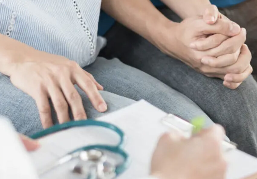 Un couple se soutient en se serrant la main dans le combat pour la fertilité